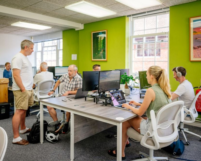 Men and women working at desks in a coworking space