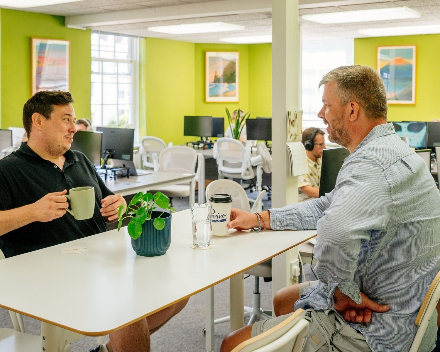 men talking at desk with coffee