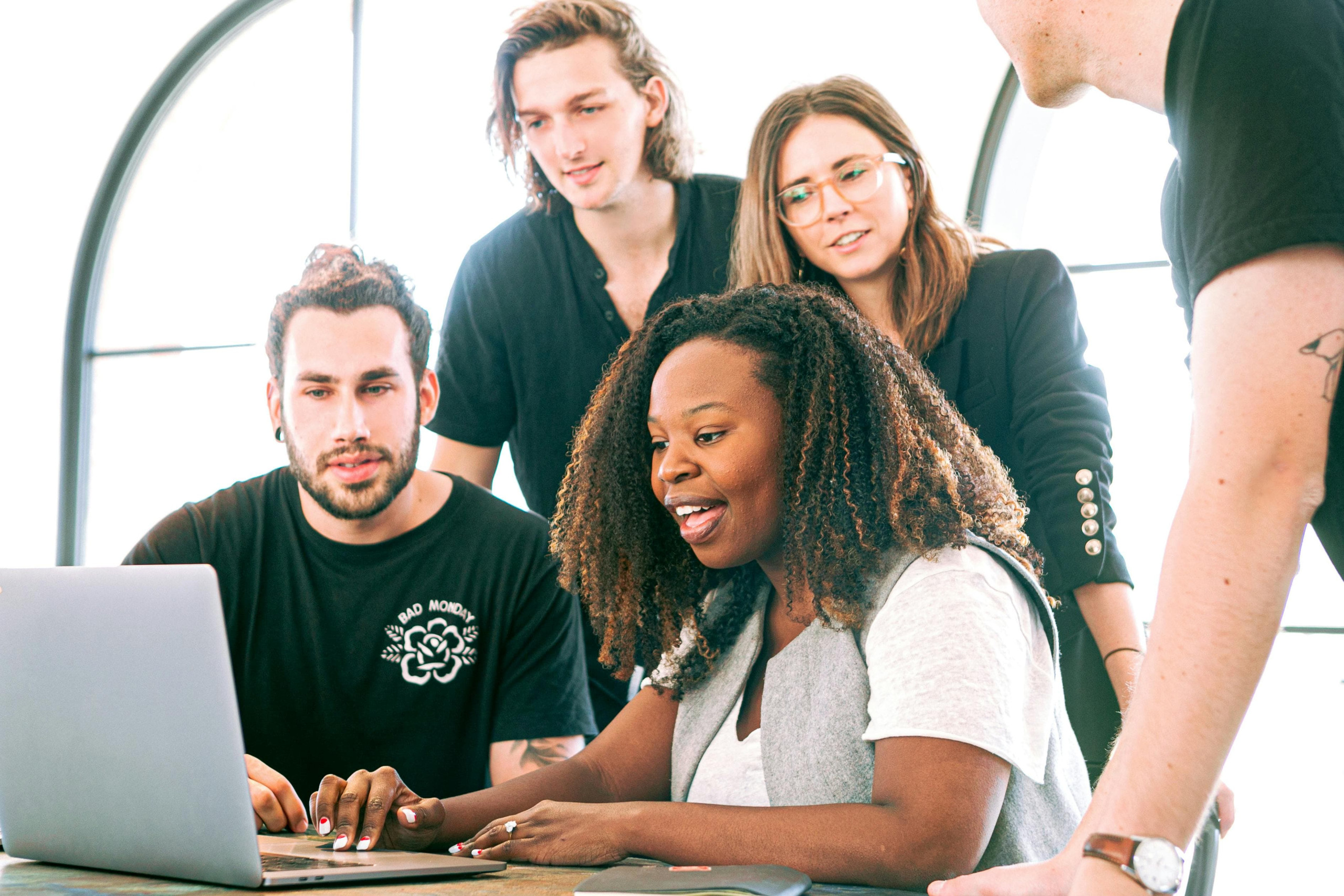 Five people gathered around a laptop