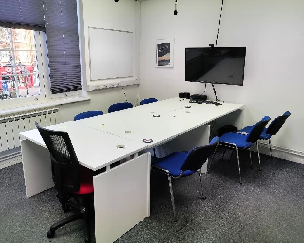 Large meeting room table with wall mounted screen