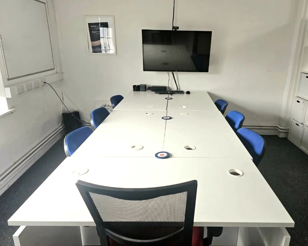 large meeting room with table for up to 8 people and wall mounted screen